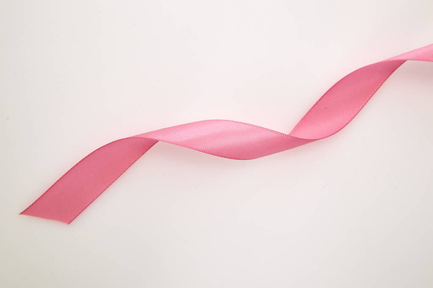 Curled pink ribbon on white background, Empty space for design - 写真・画像