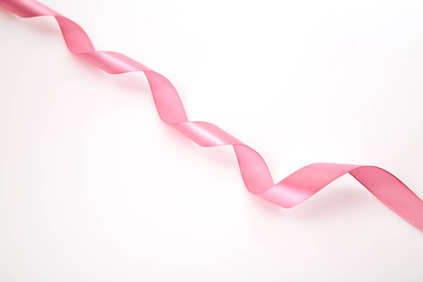 Curled pink ribbon on white background, Empty space for design - Foto, imagen