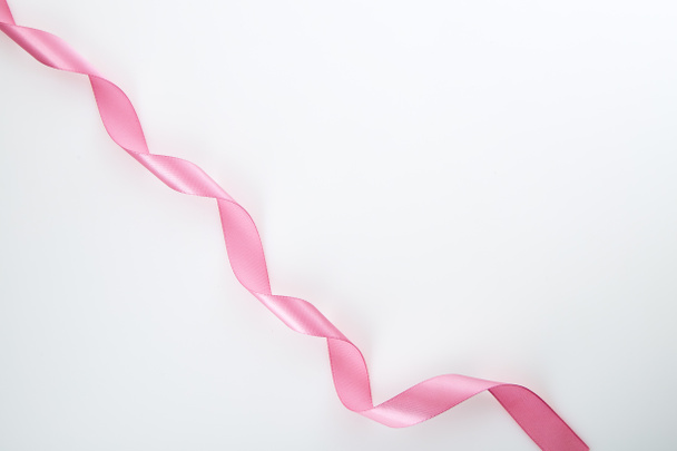 Curled pink ribbon on white background, Empty space for design - Foto, imagen