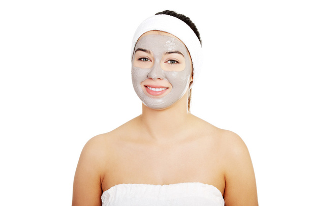 Beautiful woman with clay facial mask - Фото, зображення