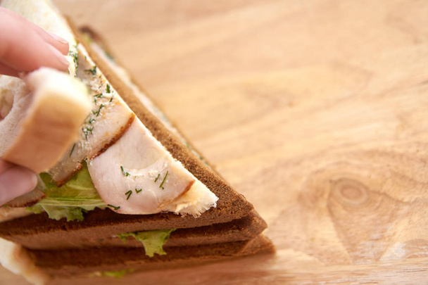 Sandwich with ham. White and black bread. Light background. - 写真・画像