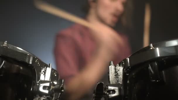 Long-haired drummers play drum kit in a dark room on a black background. Rock musician. Static plan. Wide angle - Video