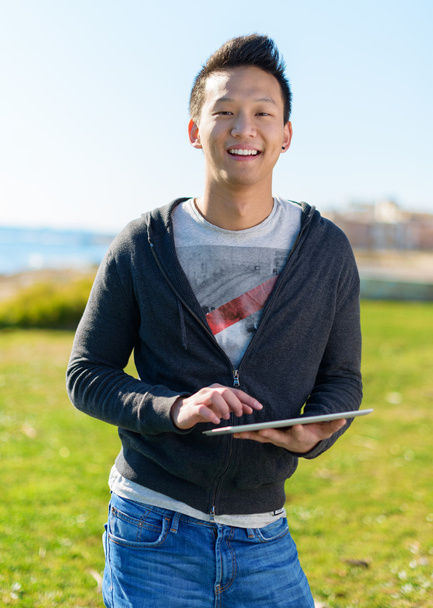 молодий чоловік тримає цифровий планшет
 - Фото, зображення