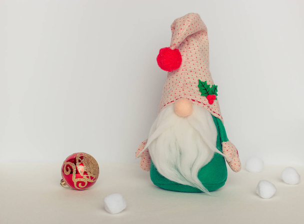 scandinavian swedish gnome in green clothes with a christmas ball isolated on white background - Photo, Image