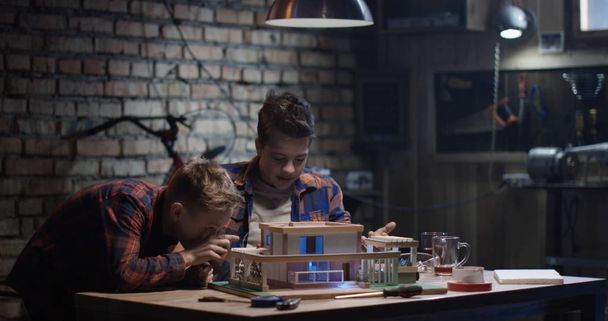 Dos chicos reparando una casa modelo
 - Foto, imagen