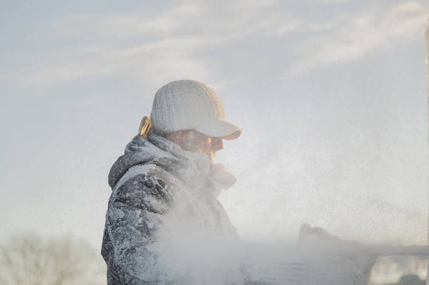 Kuvanveistäjä leikkaa jään ääriviivat jouluna moottorisahalla
 - Valokuva, kuva