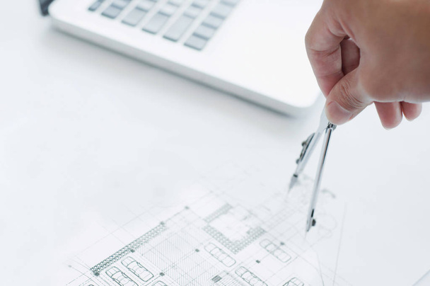 Primer plano del ingeniero dibujando a mano un proyecto de construcción con Laptop en el lugar de trabajo
 - Foto, Imagen
