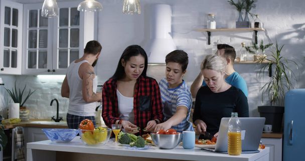 Gruppe von Menschen bereitet Essen in der Küche zu - Foto, Bild