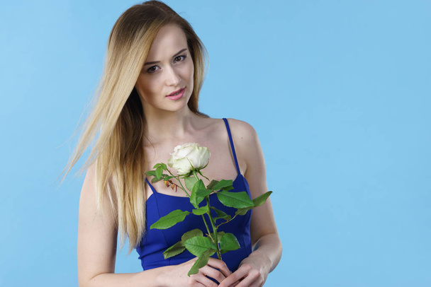 Attractive blonde young woman holding white rose flower. Valentines and womens day, gift concept. - Photo, image