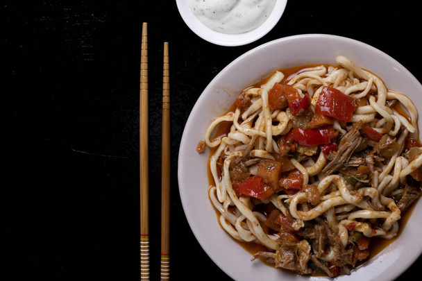 Asiatische Mahlzeit auf Teller mit Sauce und zwei Essstäbchen, Platz für Text - Foto, Bild