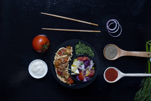 τηγανισμένα noodles και φαγητό μπαστούνια, μπαχαρικά σε κουτάλια - Φωτογραφία, εικόνα