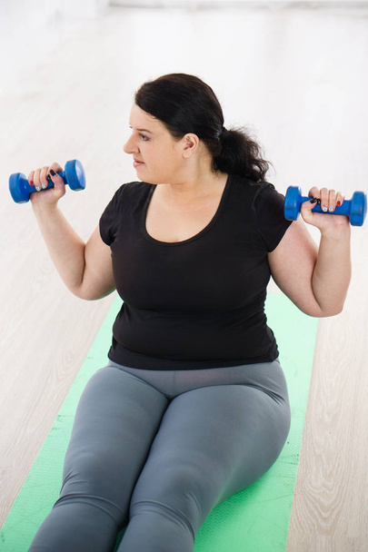 overweight woman training with dumbbells - Foto, imagen
