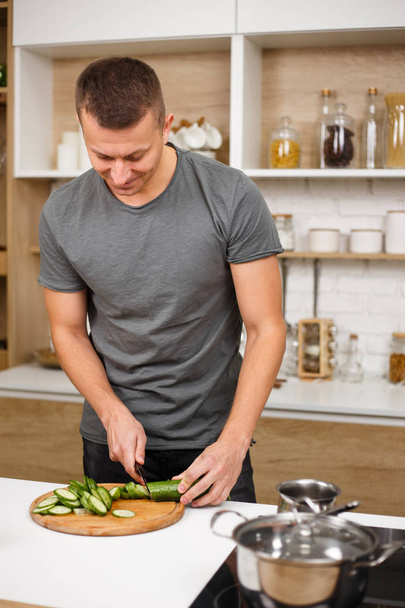 fit muscled man cooking healthy vegetable salad - Foto, afbeelding