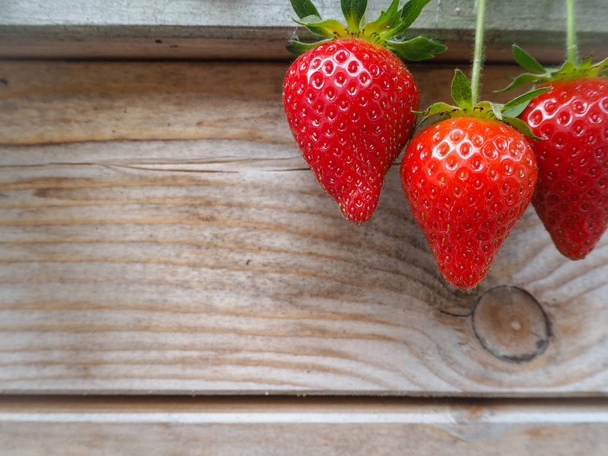 Ripe red strawberry on a wooden background - Photo, Image