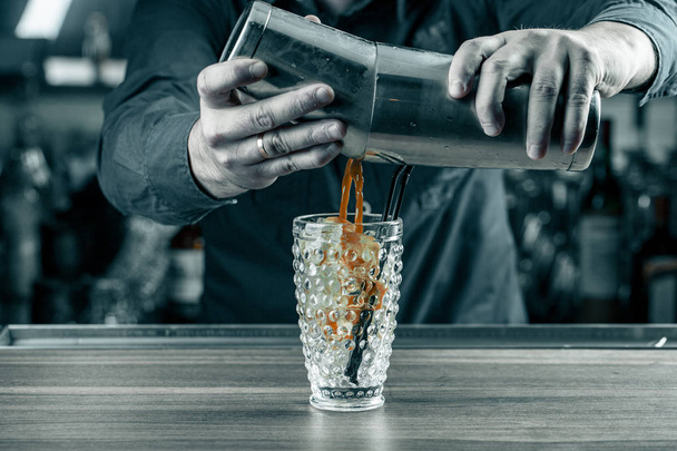 young barman worker at bartender desk in restaurant bar preparing coctail - Photo, Image