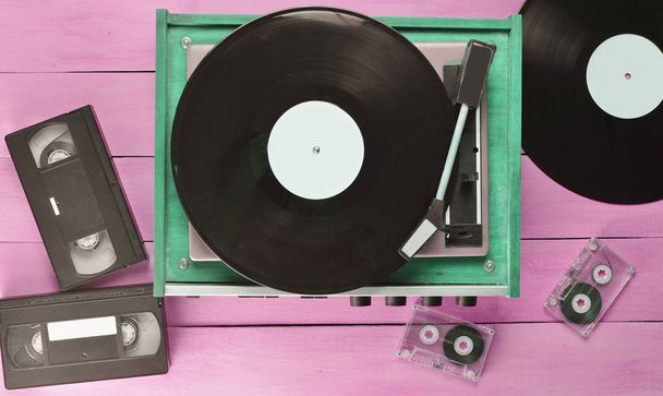 Vintage vinyl hráč s desky, video kazety, audio kazeta na modrém pozadí dřevěná. Pohled shora. Retro mediální technologie - Fotografie, Obrázek