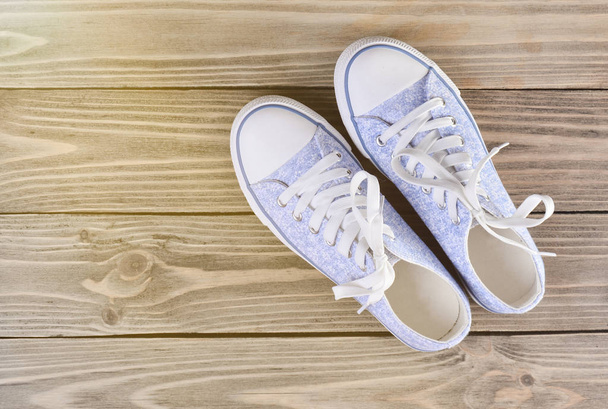 Female hipster sneakers with white laces on a pastel wooden floor, top vie - Photo, Image