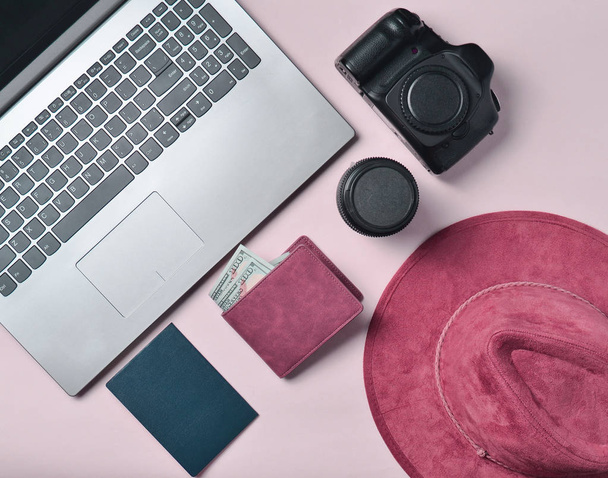 Trabajo del fotoperiodista. Laptop, billetera, pasaporte, sombrero, cámara, lente. Concepto de viaje, vista superior, plano la
 - Foto, imagen