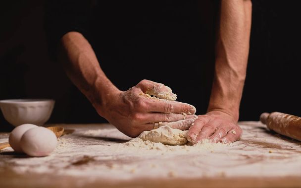 cropped shot of man kneading dough on kitchen table  - Фото, изображение
