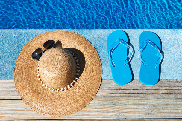 Blue slippers and hat by a swimming pool - Photo, Image
