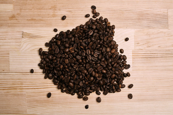 top view of roasted organic coffee beans on wooden surface - Photo, Image