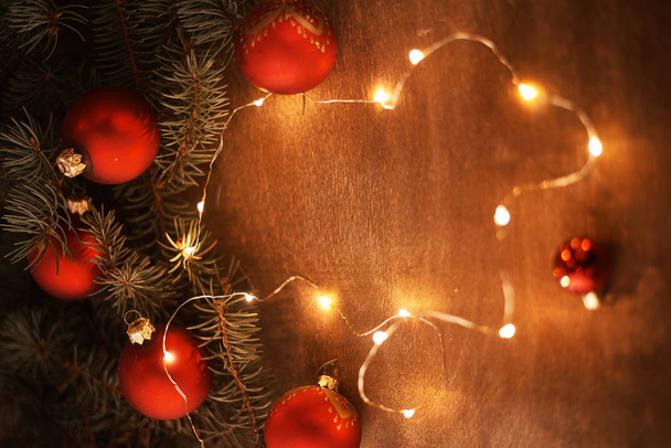 pohled shora zelené jedle větviček s červené vánoční ozdoby a osvětlené věnec   - Fotografie, Obrázek