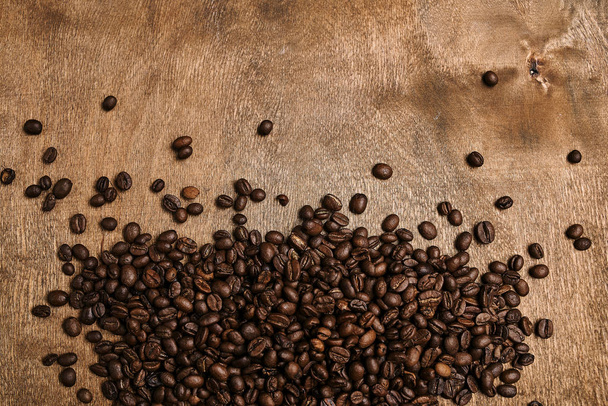 верхний вид жареных ароматических кофейных зерен на деревянный стол
  - Фото, изображение