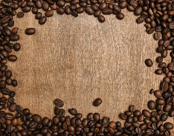 top view of roasted aromatic coffee beans on wooden table - Photo, Image