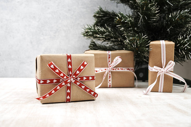 christmas gift boxes wrapped by festive ribbons near christmas tree - Фото, изображение