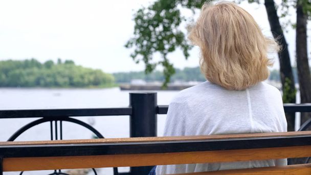 Aged female looking at river, thinking of life, countryside tranquility, rest - Фото, изображение