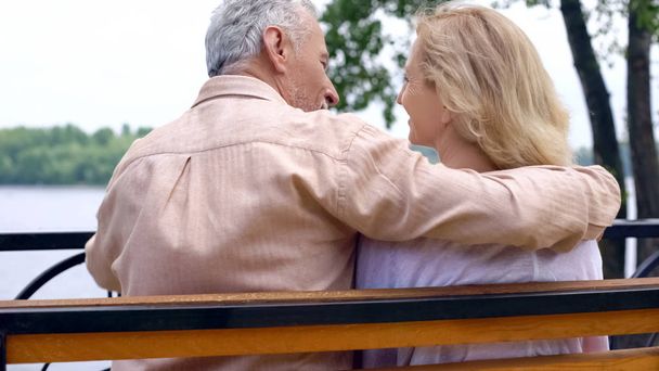 Happy retired couple relaxing on park bench, enjoying weekend outside, love - Foto, immagini