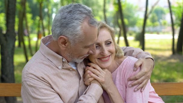 Gelukkige senior paar omarmt in park, man, vrouw, liefde tot ouderdom knuffelen - Foto, afbeelding