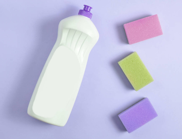Πλαστικό μπουκάλι απορρυπαντικού πιάτων, σφουγγάρια στο ροζ παστέλ φόντο, το top view, επίπεδη lay, minimalis - Φωτογραφία, εικόνα
