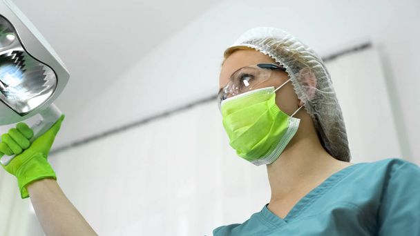 Dentist in protection mask glasses and cap preparation before oral examination - Foto, imagen