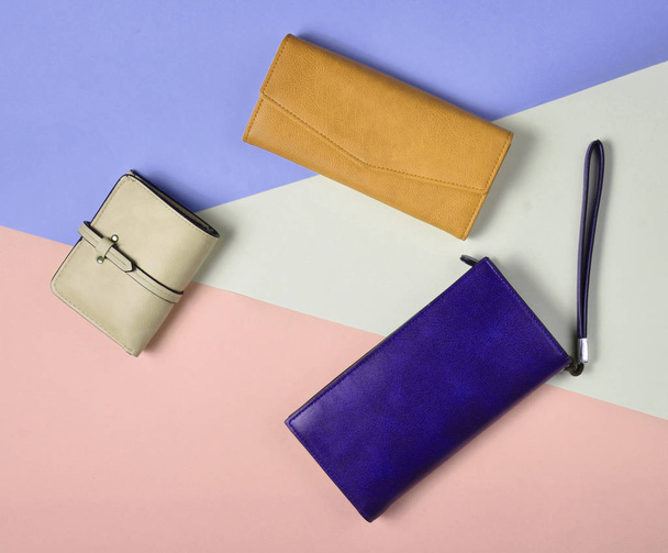 Variedad de monedero de cuero sobre un fondo pastel de colores, vista superior, minimalis
 - Foto, Imagen