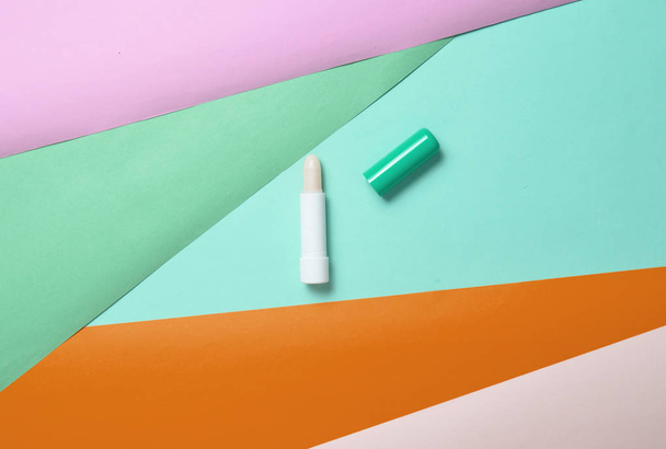 Hygienic lipstick on a colored paper background, minimalism, top vie - Foto, imagen