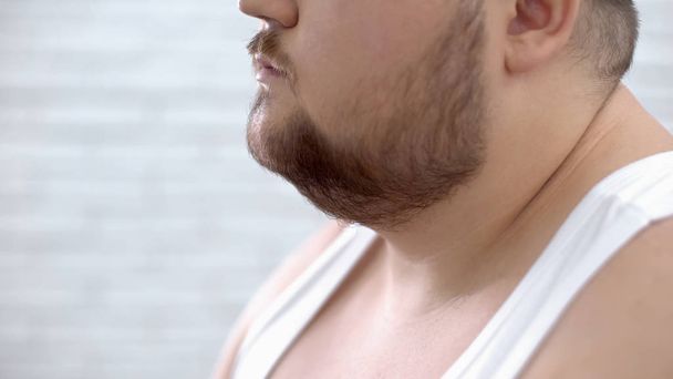 Closeup of fat bearded man in white shirt, obesity problems, lack of self-care - Фото, изображение
