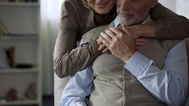 Elderly lady hugging her husband from behind, loving relations, tenderness - Fotoğraf, Görsel