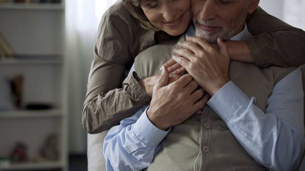 Happy elderly wife hugging husband, man holding her hands, harmonic relations - Foto, Imagen