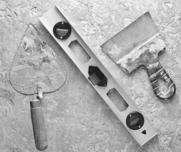 Stavební nástroje na šedém pozadí betonové. Špachtle, stěrky, úrovně, úrovně, horní vie - Fotografie, Obrázek