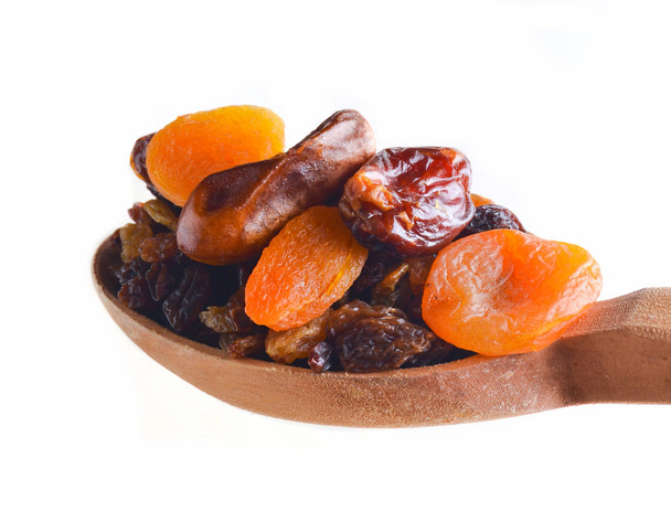 Wooden spoon with dates, dried apricots, raisins isolated on white background. Dried fruit - Photo, Image