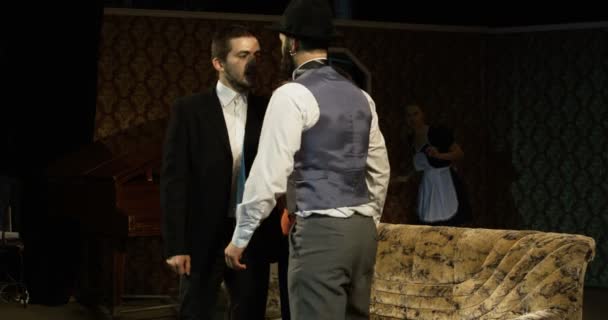 Mediana toma de actores realizando una escena donde una mujer mediando entre dos hombres en disputa
 - Metraje, vídeo