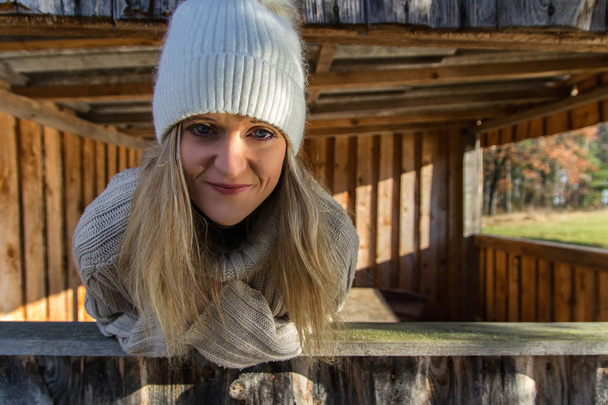 Portrét krásy mladých v bílé čepici z dřevěné budovy - Fotografie, Obrázek