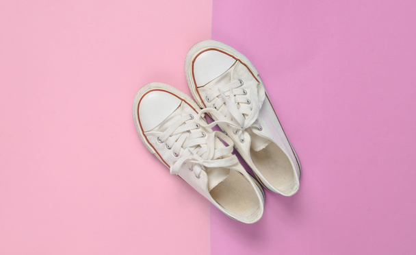 Viejas zapatillas retro con cordones blancos sobre un fondo pastel rosa azulado. Minimalismo. Top Vie
 - Foto, imagen