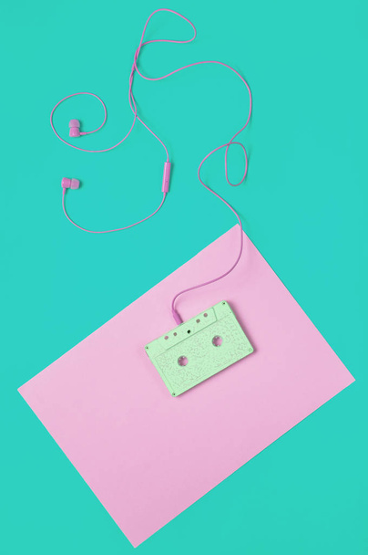 Audio cassette and earphones on a blue yellow pastel background. Musical concept. Retro style. Minimalism. Top Vie - Photo, Image