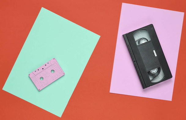 Audio cassette and video cassette on a colored paper background. Retro entertainment technology from the 80s. Top view. Minimalism. Copy spac - Photo, Image