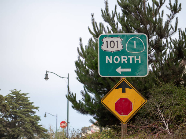 101 Segnale di stop nord che punta avanti e a sinistra vicino agli alberi
 - Foto, immagini