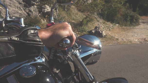 Motorcu motor üzerinde el closeup. Hisse senedi. Gaz önce başlamak motosikletçi deri eldiven içinde yakın çekim el presler - Fotoğraf, Görsel