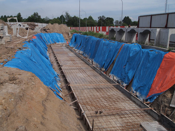 Temporary slope protection using huge plastic sheet at the construction site. It is to keep the soil profile and avoid soil erosion when it rains. - Photo, Image