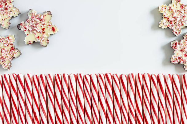 Five chocolate peppermint bark snowflakes with row of red and white striped peppermint candies - Foto, Imagem